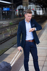 man checking the time and waiting for train