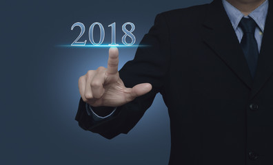 Businessman pressing 2018 text over blue background, Happy new year concept