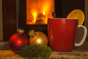 one red mug with christmas balls and fireplace