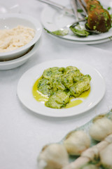 Italian food - ravioli with fresh pesto sauce in a white ceramic plate.