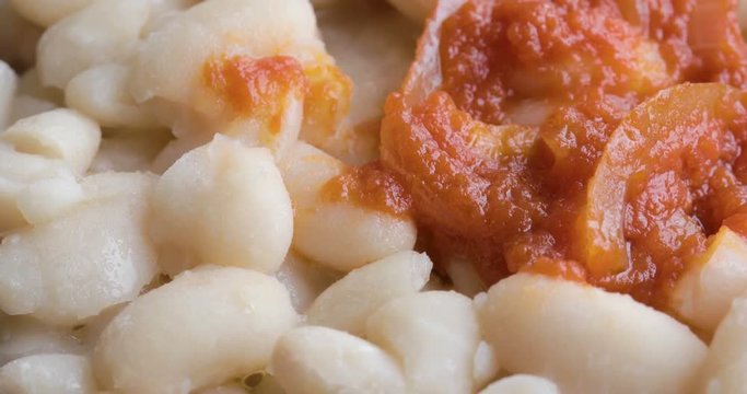 Fagioli bianchi con salsa al pomodoro piccante e cipolla su un piatto nero