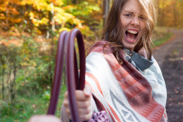 angry woman holding her purse while someone wants to take it