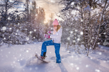 Winter sport activity. Woman with snowshoes on fluffy snow in forest. Beautiful landscape with...