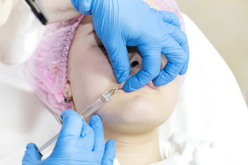 The girl undergoes the procedure of cosmetic surgery to increase the lips 