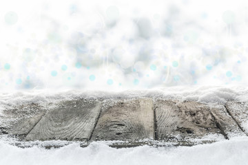 Verschneiter Holzboden vor Winterhimmel mit Bokeh