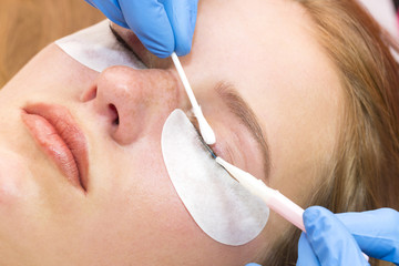 Woman on the procedure for eyelash extensions, eyelashes lamination 
