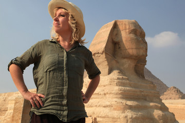 blonde Frau aus Froschperspektive vor Sphinx guckt wie eine Forscherin