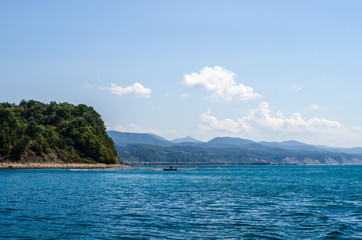 Landscape with the sea, mountains and a little boat