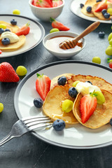 Homemade Pancakes with Blueberry, Strawberry, green Grape and honey syrup. served on plate
