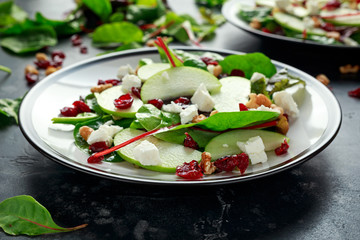 Homemade Autumn Apple Cranberry Salad with walnut, feta cheese and vegetables