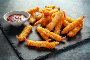 Fried Shrimps tempura with sweet chili sauce on black board stone