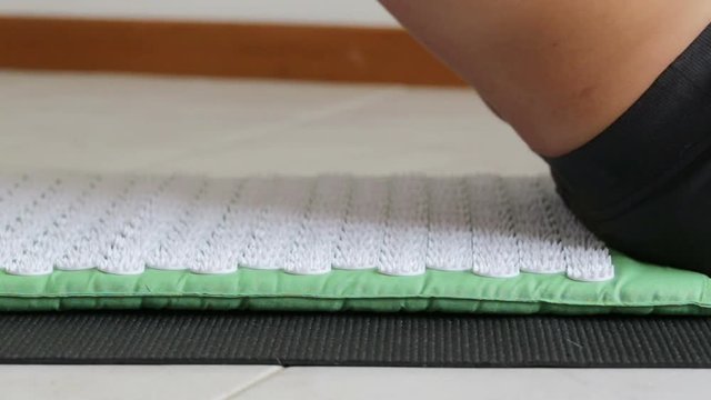 The man lies on acupuncture mat for massage. Close-up.