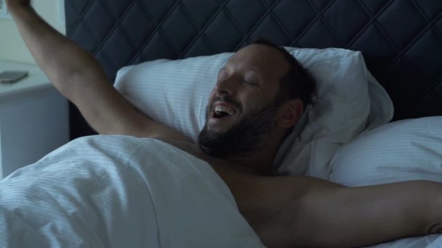 Happy man waking up from sleep in bedroom, super slow motion 240fps
