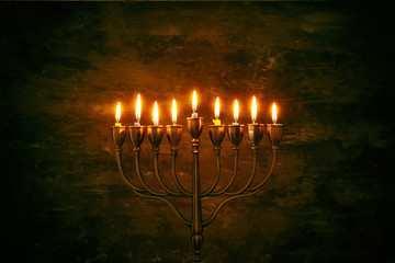 Low key image of jewish holiday Hanukkah background with menorah (traditional candelabra) and burning candles © tomertu