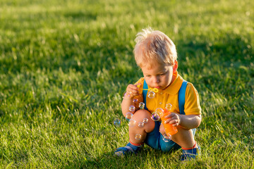 One year old baby boy blowing soap bubbles