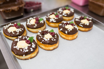 Chocolate glazed decorated donuts ready for sale in a small town bakery. Selectiv focus.