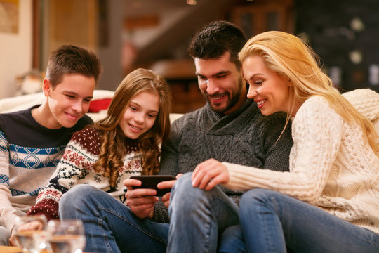 Parents with children looking photos on cell phone