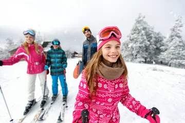 Papier Peint photo Sports dhiver Girl skier skiing with family on mountain