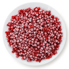 Frozen redcurrants on white ceramic plate isolated on white from above.