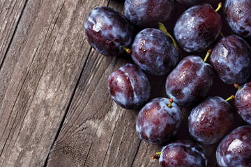 fresh plums on wooden table.
