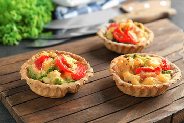 Delicious crispy tarts with broccoli on wooden board