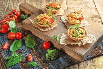 Fototapeta na wymiar Delicious crispy tarts with broccoli on wooden board