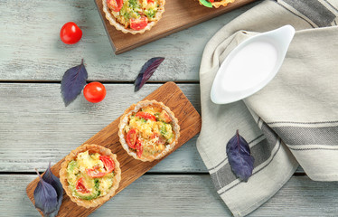 Delicious crispy tarts with broccoli on wooden board