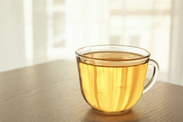 Glass cup with oil on wooden table