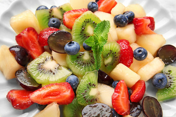 Plate with delicious fruit salad, closeup