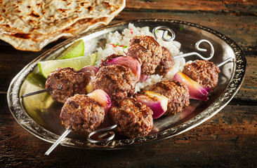 Roasted oriental kofta recipe served with rice on metal plate