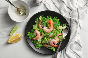 Plate with fresh tasty shrimp salad on table