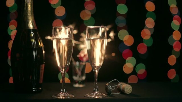 Two glasses of champagne on the background of burning sparkler