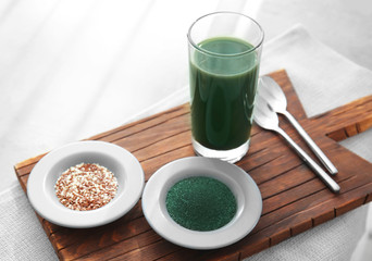 Spirulina drink, powder and seeds on wooden board