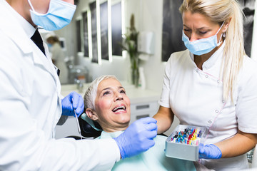 Beautiful senior woman at dentist having dental treatment at dentist's office.