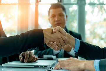 Businessmen shake hands and finish meeting in daylight.