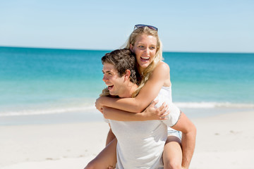 Portrait of man carrying girlfriend on his back