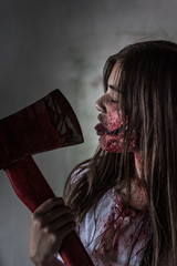 Portrait Zombie or Ghost woman with bloody holding axe