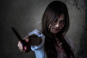 Portrait Zombie or Ghost woman holding point knife