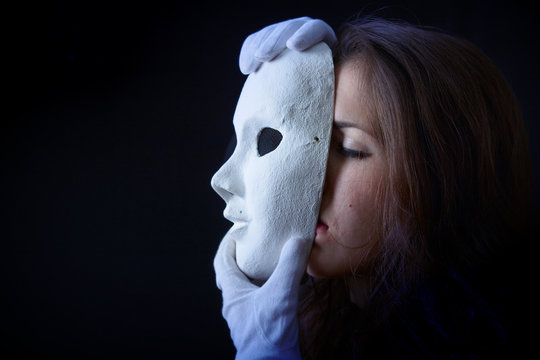 Brunette Girl Is Holding A Theater Mask In Front Of Their Face