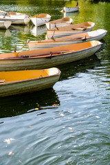 Fototapeta na wymiar A fleet of rental rowboats bound to one another at the end of the day on the Lower Lake in the Bois de Boulogne in Paris.