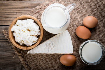 Tasty dairy products on rustic wooden table, top view.