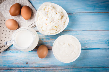 Tasty dairy products on rustic wooden table, top view.