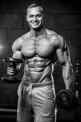 Obraz na płótnie Canvas Brutal Caucasian bodybuilder working out in gym