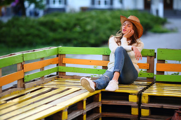 Enjoying young woman siting on bench, street outdoor, resting city, closed eyes