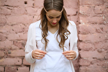 Beautiful young hippie woman, upper half, on puffy brick background