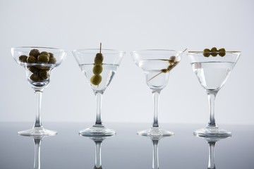 Cocktail martini with olives on table