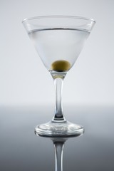 Cocktail martini with olives on table