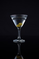 Cocktail martini with olives on table