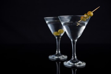 Cocktail martini with olives on table