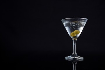 Cocktail martini with olives on table